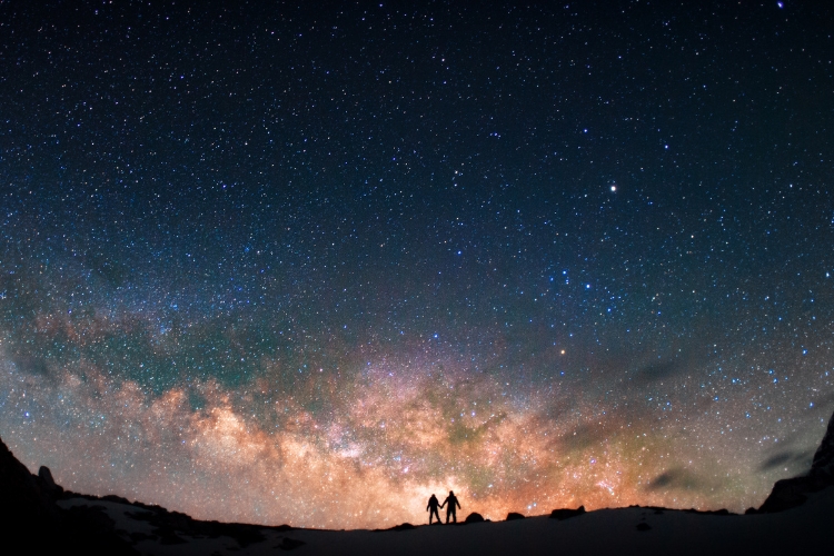 two people standing under the stars