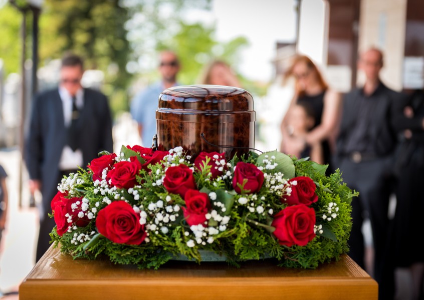 Funerary urn with ashes of dead and flowers at funeral.jpg