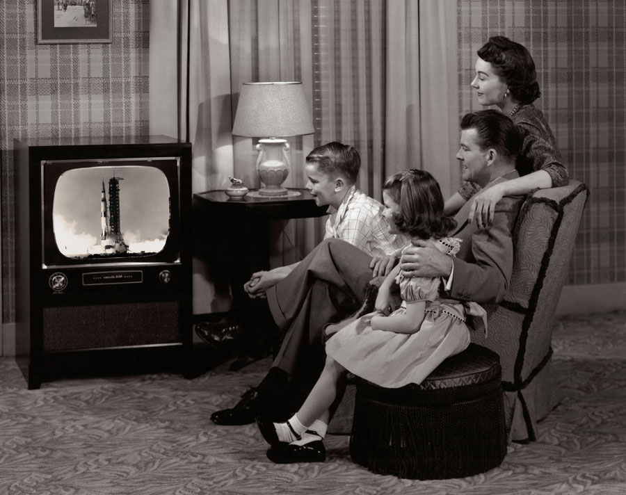 Family sits in front of television to witness an Apollo mission.