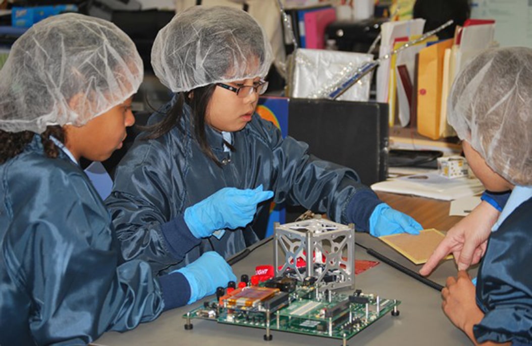 Elementary students building a satellite
