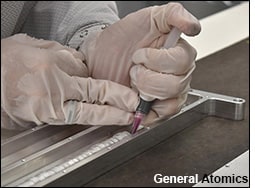 A technician inserts Celestis capsules filled with the ashes of 152 different people on the Orbital Test Bed satellite.