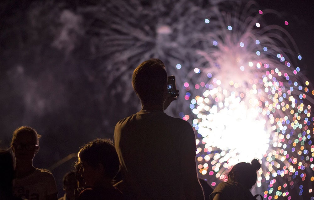 man taking picture of firecracker