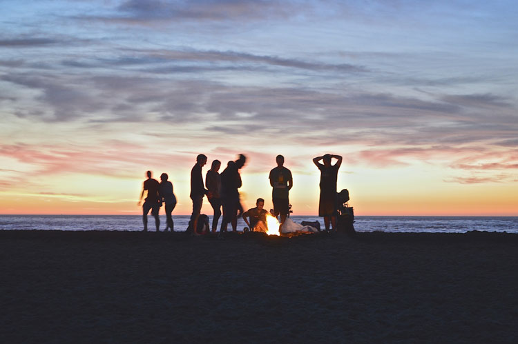 group of friends campfire on the beach