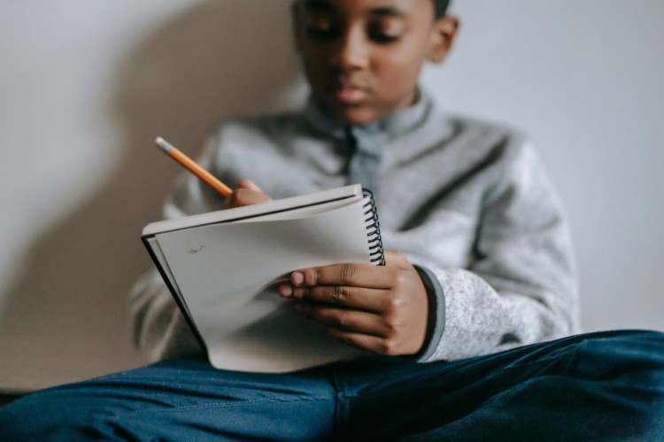 a kid writing in a notebook