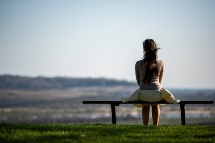 a woman sitting alone on the bench