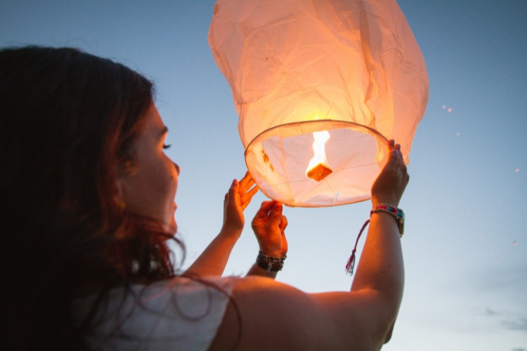 woman holding a paper memorial lantern