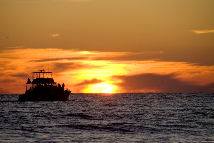 serene and picturesque scene of a boat gliding gently on calm waters during sunset