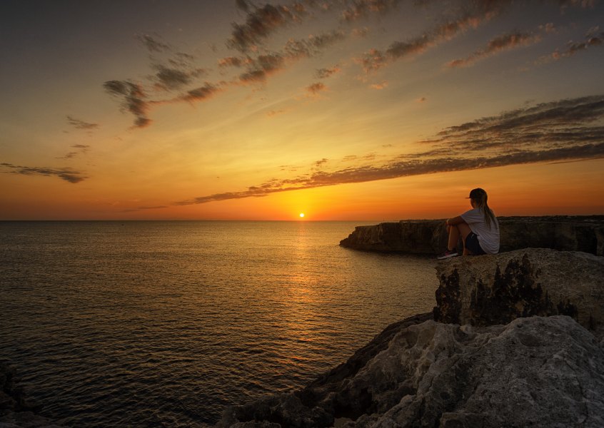 woman sitting on a rock at sunset.jpg