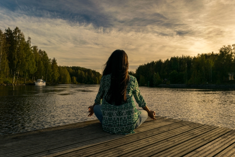 woman sitting in peace looking at the lake