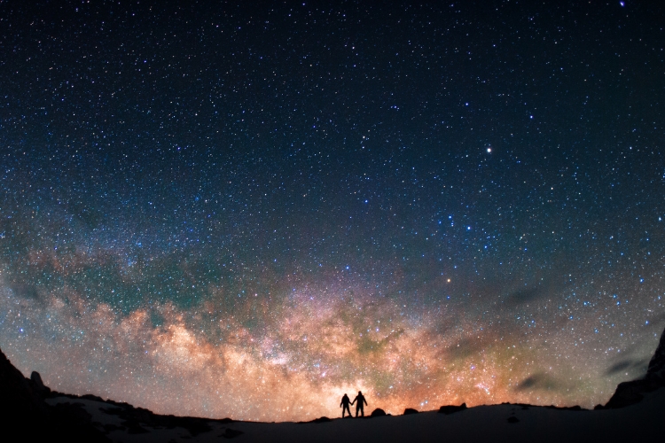 two people standing under the stars