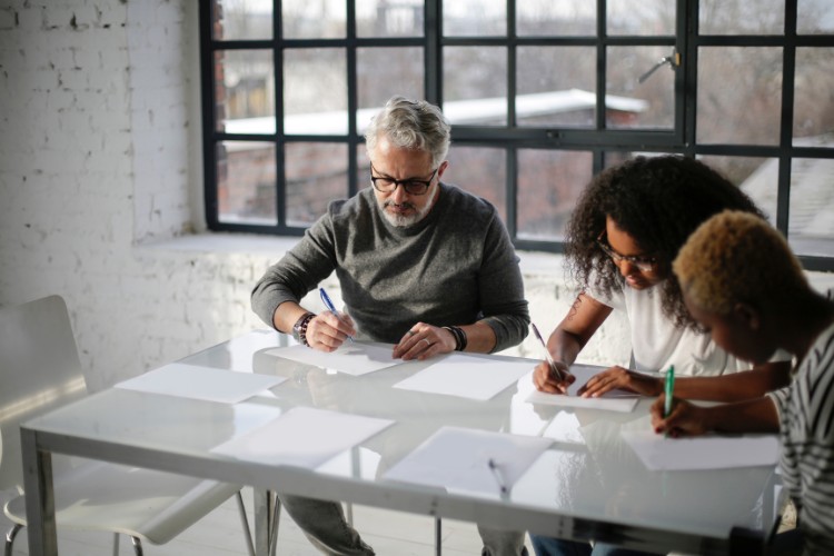 people sitting near a table writing