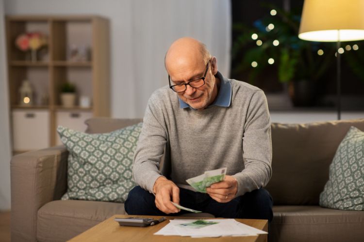 a senior man counting money at home