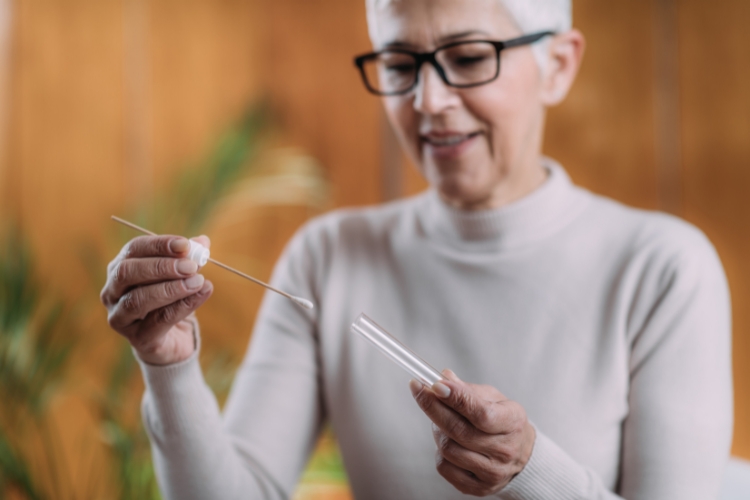 a woman holding a cotton swab and a tube