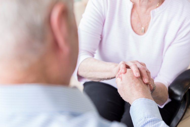 elderly man and woman holding hands