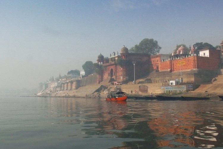 boat in ganges river scattering ashes