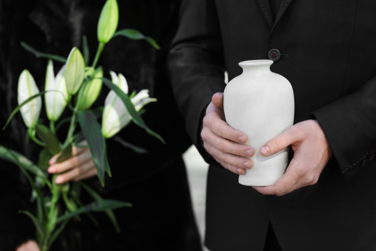 hands holding urn and flowers