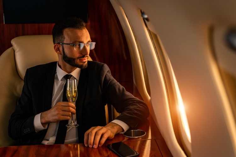 rich man on a plane drinking wine
