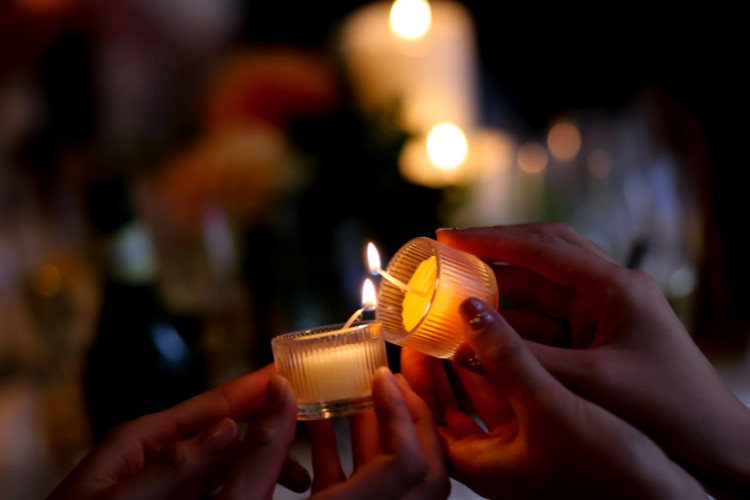 Memorial attendees participating in a candle tribute ceremony