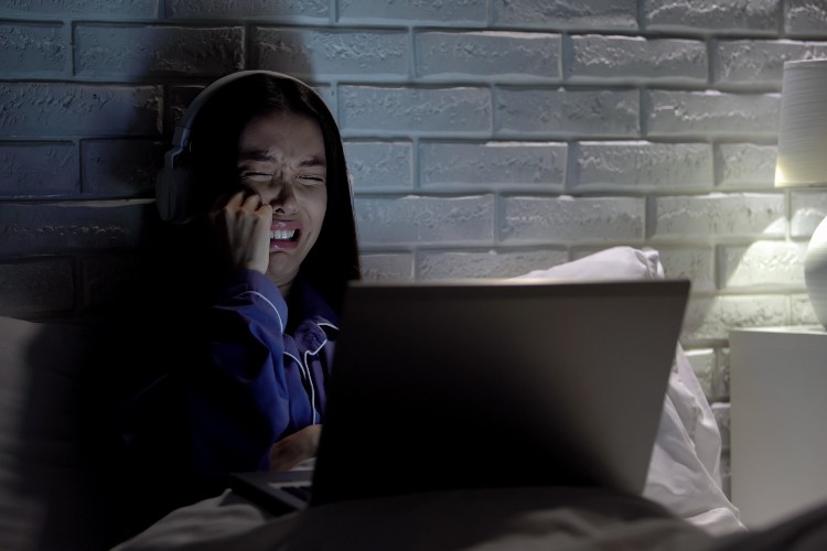 Grieving person attending a virtual memorial service from home