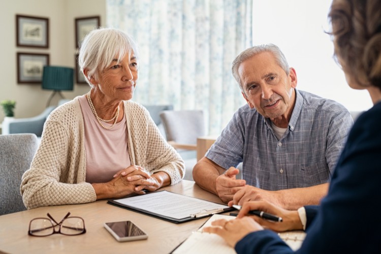 Senior couple discussing DNA Banking and cremation memorial planning services with advisor