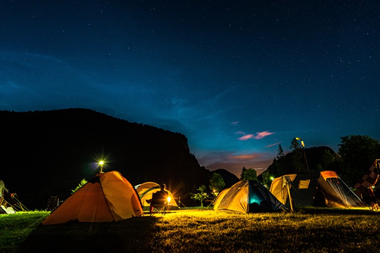 Celebration of life gathering with tents under a starry night sky in a national park