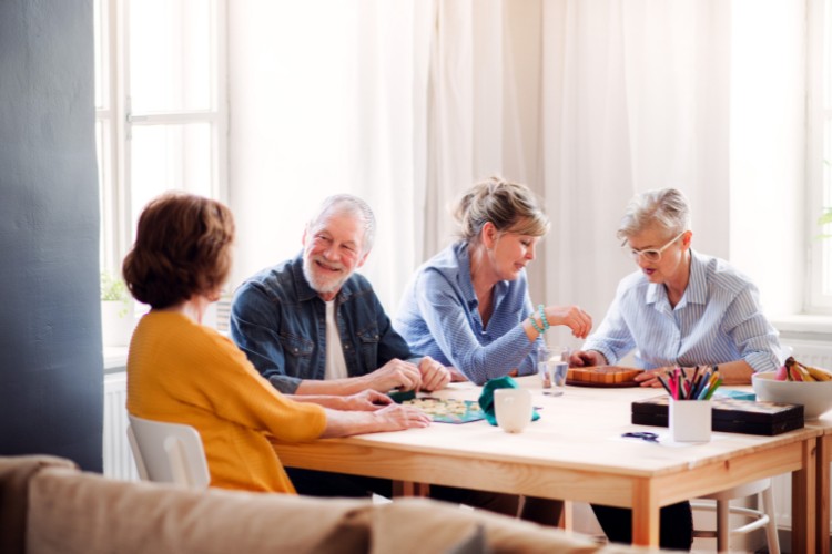 Seniors and loved ones sharing stories during a celebration of life at a community center
