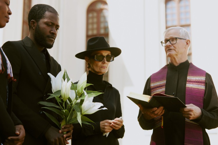 Family standing with officiant during religious memorial service
