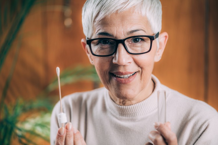 Woman holding DNA swab and collection tube for genetic preservation