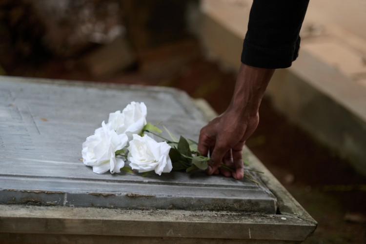 Gravesite scene showing flowers laid on a headstone in remembrance of a grandparent